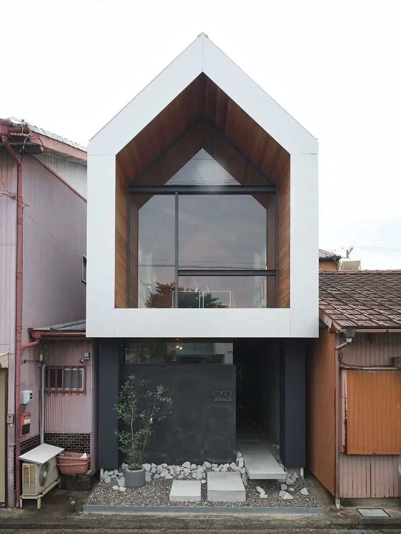 白い三角屋根と大きな窓が特徴のモダンな住宅の外観